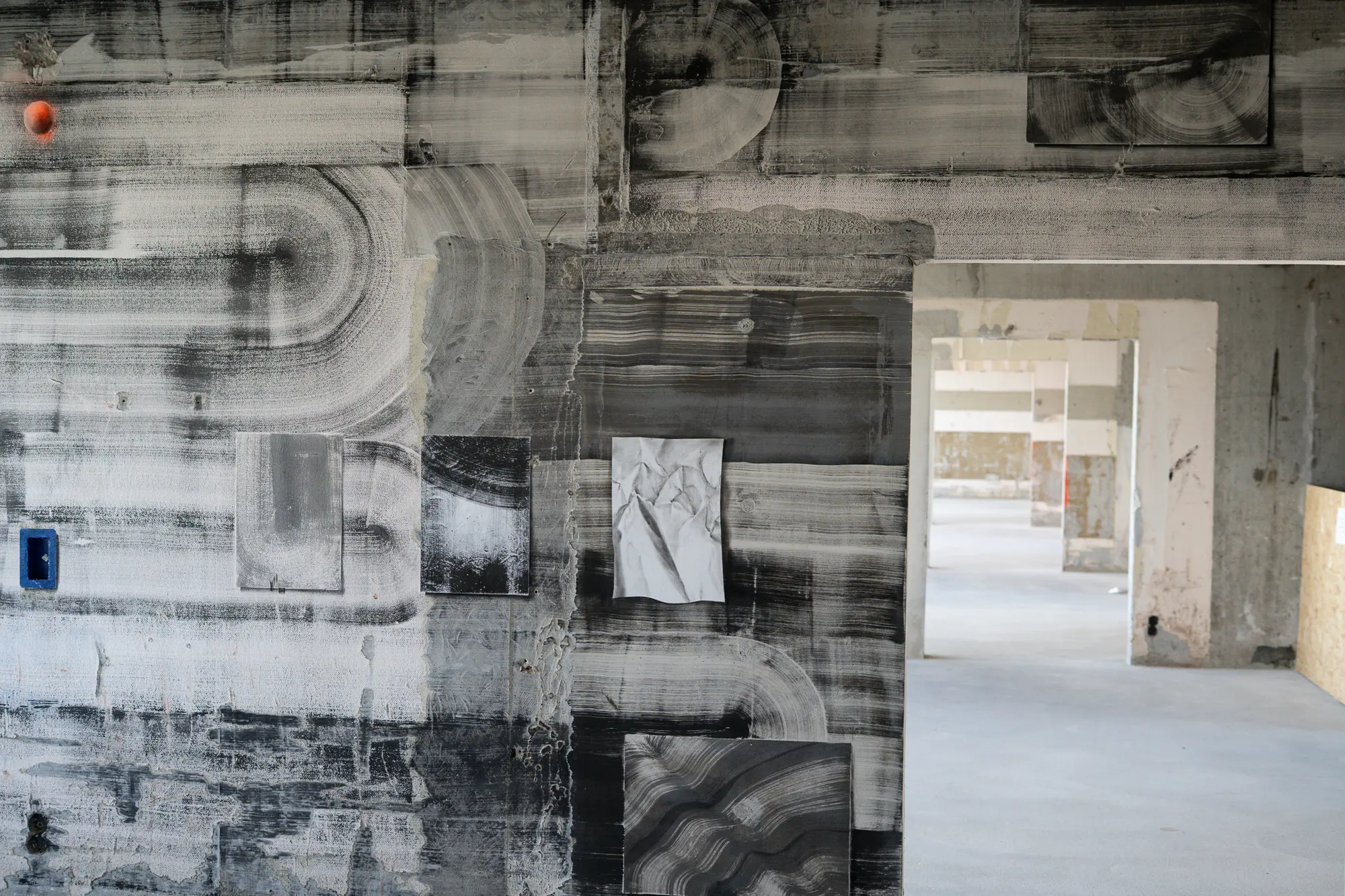 Raw concrete wall with black and white printed murals at Het Slotervaart